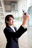 Young businesswoman taking picture by camera in mobile phone