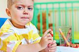 Little cute boy draws with crayons in the nursery