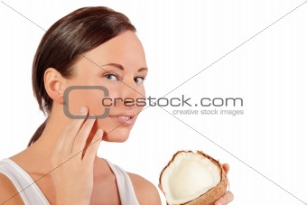 Woman applies cream to her face