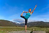 Woman practices yoga in the mountains