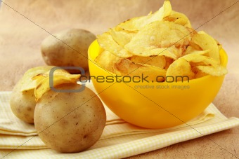 potato chips in a yellow cup, and fresh potato