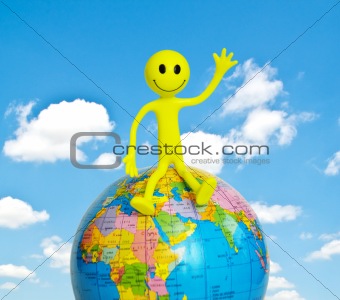 On top of the world - smilie sitting on the globe