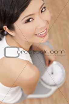 Oriental Asian Chinese Woman Weighing Herself on Scales at Gym 