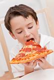 Young Boy Child Eating Slice of Pizza