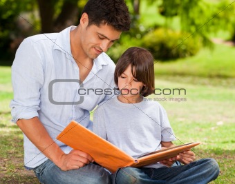 Son with his father looking at their album photo