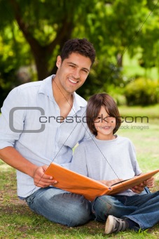 Son with his father looking at their album photo