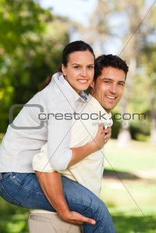Man giving to his wife a piggyback