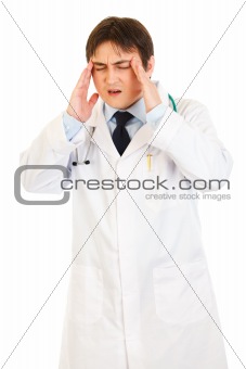 Medical doctor with headache holding hands at head
