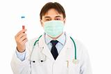Medical doctor in mask  holding blood sample in hand
