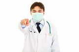Medical doctor in mask pointing finger at you
