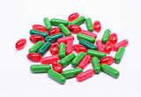 Red and green pills on white background 