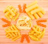 Different kinds of italian pasta on the wooden background 