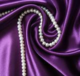 White pearls on a lilac silk background 