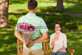 Young man offering flowers to his wife