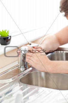 Close-up of a young man repairing his sink in the kitchen