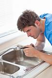 Manual man repairing his sink in the kitchen