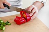 close-up of a man cutting red pepper standing in the kitchen 