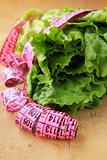 green salad diet with a pink measuring tape