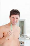 smart young man holding his toothbrush in the bathroom in the mo