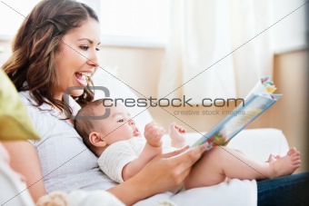 Charming mother showing images in a book to her cute little son