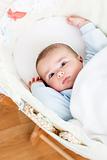 Portrait of a bright baby lying in his cradle