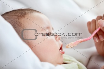Close-up of a mother giving food to her cute baby