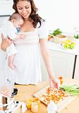 Radiant mother preparing food for her adorable baby in the kitchen
