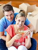 cheerful couple celebrating their new house with champagne