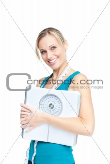 bright woman holding a scale and a measuring tape smiling at the