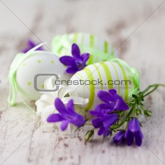 Easter eggs and spring flowers on wood background