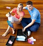 Beautiful couple sits on the floor picking colors