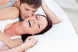 Affectionate caucasian couple lying on bed