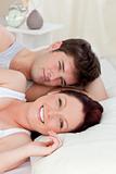 Positive caucasian couple lying on bed