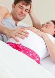 Happy pregnant woman lying on bed with her husband