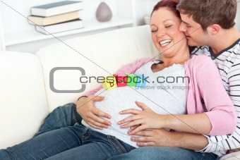 Portrait of a merry pregnant woman with baby cubes on her belly 