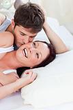 Cheerful caucasian couple lying on bed