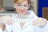 Portrait of a smiling female scientist holding different samples