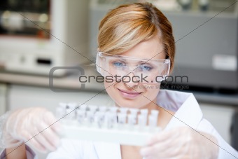 Portrait of a beautiful female scientist holding different sampl