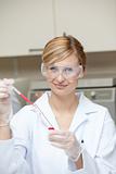 Close-up of a female scientist putting liquid in a test tube wit