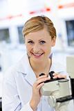 Delighted female scientist using a microscope