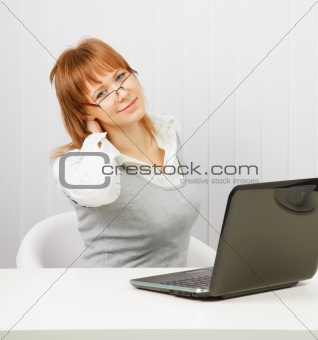 tired girl with a laptop stretches