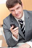 Elegant businessman writing a text message with his mobile phone