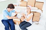Concentrated young couple unpacking boxes with glasses
