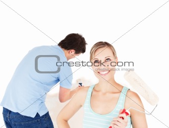 Positive couple painting a room