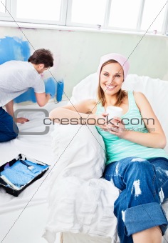 Smiling woman sitting on the sofa looking at the camera