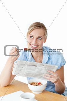 Glowing businesswoman having breakfast and reading a newspaper s
