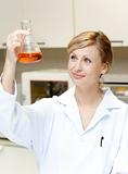 Portrait of a bright female scientist looking at an erlenmeyer