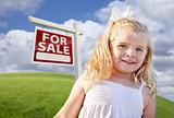 Adorable Smiling Girl in Grass Field with For Sale Real Estate Sign Behind Her.