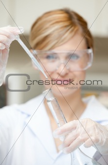 Portrait of a charming female scientist using a pipette
