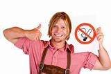 Smiling Bavarian man in lederhose holds no-smoking-rule sign